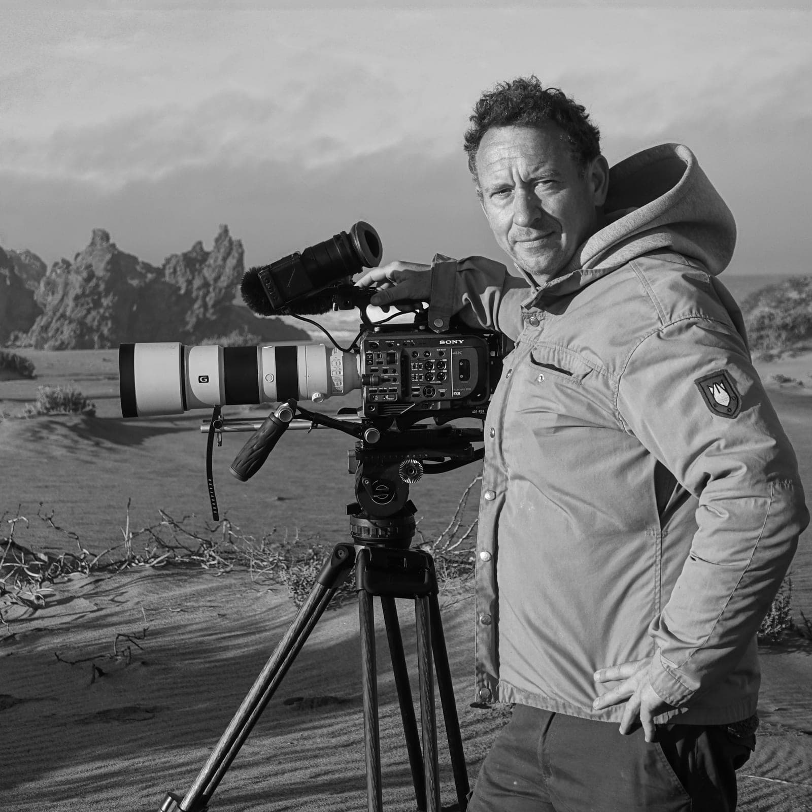 Felix Greif mit Filmkamera vor einer weiten Landschaft Felix Greif mit Filmkamera vor einer weiten Landschaft
