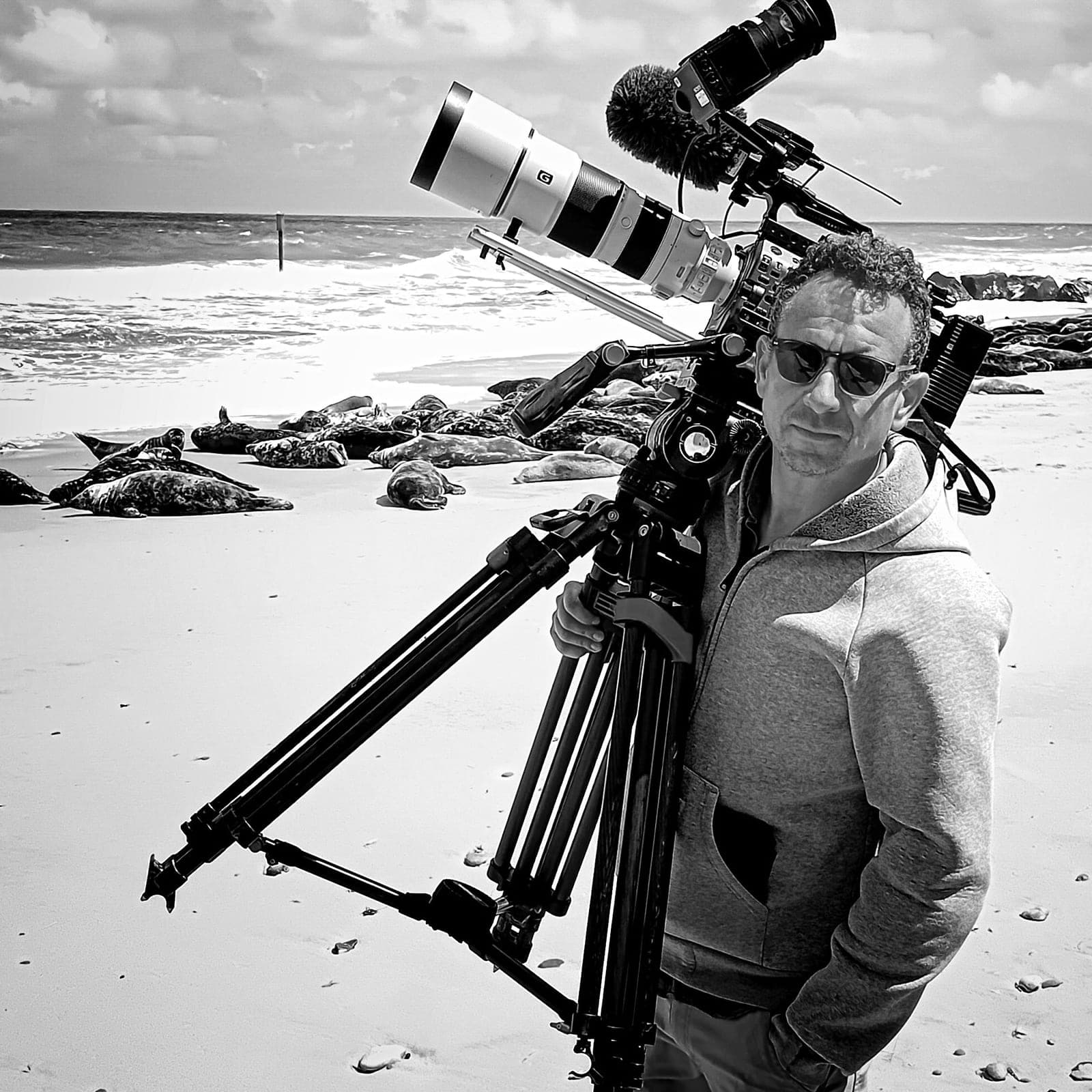 Felix Greif mit Kamera und Stativ an einer Küste Felix Greif mit Kamera und Stativ an einer Küste