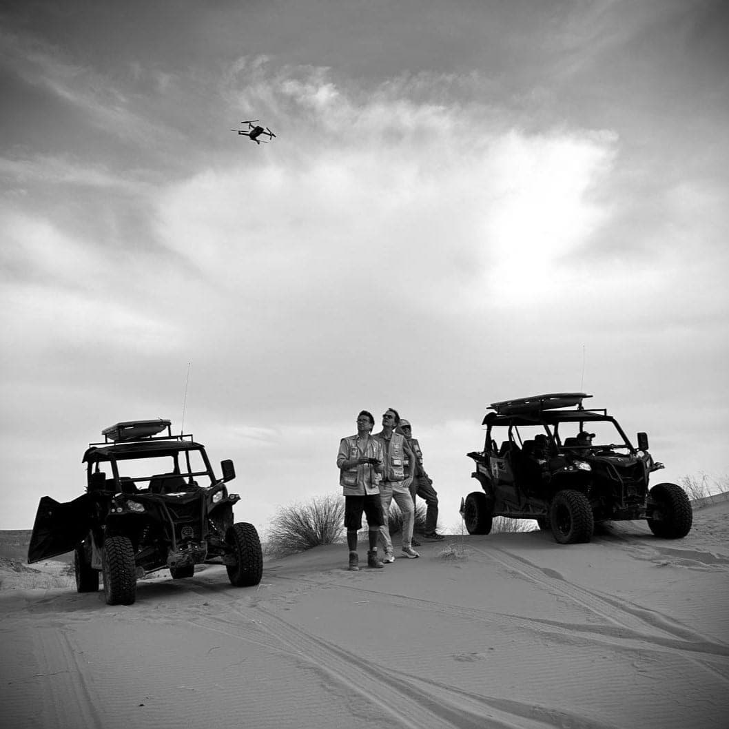 Filmteam mit Fahrzeugen in einer weiten Wüstenlandschaft Filmteam mit Fahrzeugen in einer weiten Wüstenlandschaft